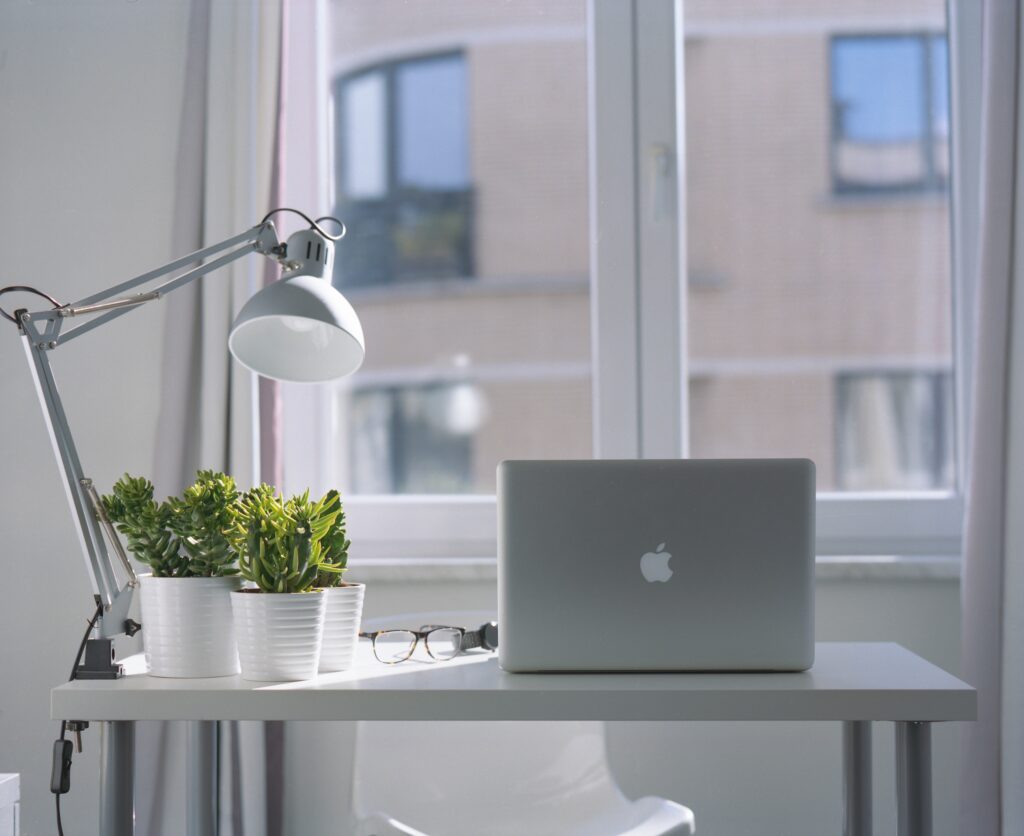 Open office window with lamp and laptop on desk