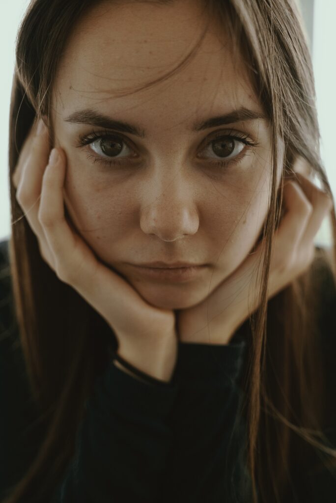 Teenage girl looking at camera with chin resting on her hands