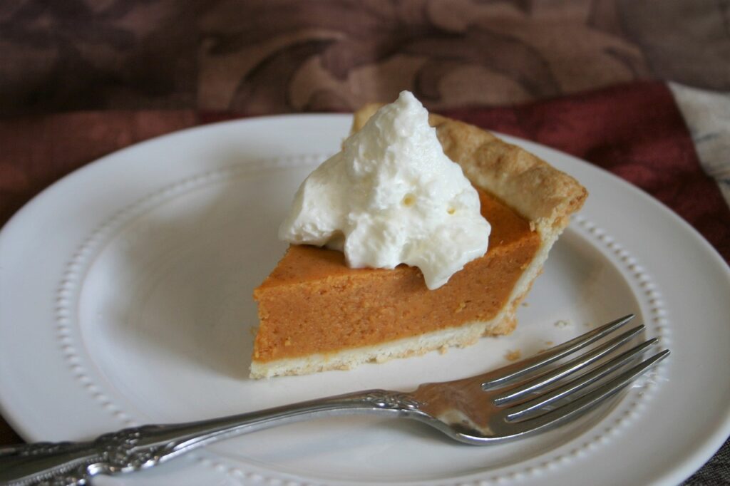 Piece of pumpkin pie with whipped cream